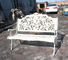 藤の白い鋳鉄のテーブルおよび椅子/骨董品は屋外の肘掛け椅子に金属をかぶせます